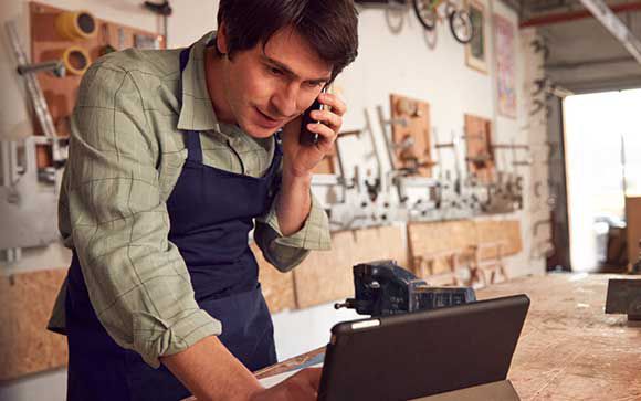 Handwerker telefoniert in der Werkstatt